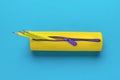 Yellow pencil case with three yellow pencils on a blue background. Flat lay Royalty Free Stock Photo