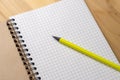 Yellow pencil on a notebook with sheets in a cage on a wooden table. Concept for shopping list, notes, planning. Top Royalty Free Stock Photo