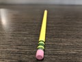 Yellow pencil with pink eraser attached lying on office desk