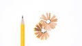 Yellow pencil placed and the sharpener chips isolated on white.