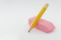 A yellow pencil rests on a pink eraser on a light background. Space for text. Royalty Free Stock Photo