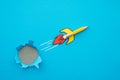 Yellow pencil rocket breaking through hole from obstacle wall to blue zone background minimal style. Concept of breakthrough Royalty Free Stock Photo