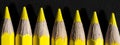 Yellow pencils all lined up on the dark black background. Royalty Free Stock Photo
