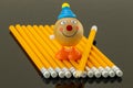 Yellow pencils arranged at a row on a black background and a fun Royalty Free Stock Photo