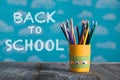 Yellow pencils holder with colorful school supplies on a wooden Royalty Free Stock Photo