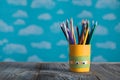 Yellow pencils holder with colorful school supplies on a wooden Royalty Free Stock Photo