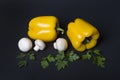 Yellow pepper with mushrooms and herbs on a dark background. Royalty Free Stock Photo