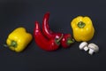 Yellow pepper and red pepper with mushrooms on a black background. Royalty Free Stock Photo