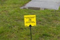 Yellow pesticide application sign on resedential front lawn Royalty Free Stock Photo