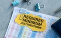 A yellow piece of paper with a clip on it that says Required Minimum Distribution Royalty Free Stock Photo
