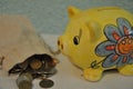 Yellow piggy bank stands on a table and canvas money sack with coins Royalty Free Stock Photo