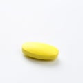 Yellow pill on white background