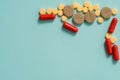 Yellow pills and capsules on a blue background. Open capsule, powdered medicine Royalty Free Stock Photo