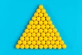 Yellow pills are presented in the form of a pyramid and a blue background Royalty Free Stock Photo