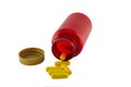 Yellow pills in a red bottle on a white background.