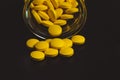 yellow pills spilling out of a toppled pill bottle Royalty Free Stock Photo