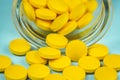 yellow pills spilling out of a toppled pill bottle Royalty Free Stock Photo