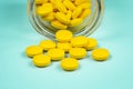 yellow pills spilling out of a toppled pill bottle Royalty Free Stock Photo