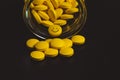 yellow pills spilling out of a toppled pill bottle - a smiley face pill - anti depression concept Royalty Free Stock Photo