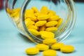 yellow pills spilling out of a toppled pill bottle Royalty Free Stock Photo