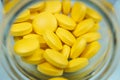 yellow pills spilling out of a toppled pill bottle Royalty Free Stock Photo