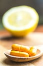 Yellow pills on a spoon next to a lemon Royalty Free Stock Photo