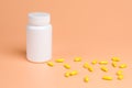Yellow pills, tablets and white bottle on orange background Royalty Free Stock Photo