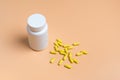 Yellow pills, tablets and white bottle on orange background Royalty Free Stock Photo