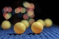 Yellow ping pong ball, with bokeh background, on black background Royalty Free Stock Photo