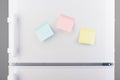 Yellow, pink and blue sticky paper notes on white refrigerator Royalty Free Stock Photo