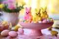 Yellow and pink Easter peeps in a plate with Easter colorful eggs on the table