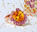 Yellow Citrine pink gemstone gold ring with white crystal and gold confetti on white background fashion jewelry women accessories Royalty Free Stock Photo