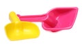 Yellow and pink plastic toy shovels on white background