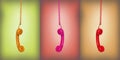 Yellow, pink and red vintage phones hanging of a cable Royalty Free Stock Photo