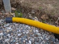 Yellow pipe on stone pebbles. Technical communications on the beach. Cable Royalty Free Stock Photo