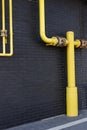 Yellow pipes, black wall