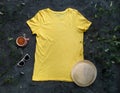 Yellow plain t-shirt mockup coffee cup dark background. Blank cotton shirt template creative design illuminating summer Royalty Free Stock Photo