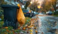 Yellow plastic bag is left on bin in the street in autumn Royalty Free Stock Photo