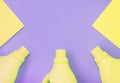 Yellow plastic bottles with chemicals for cleaning, rags for cleaning. Purple background