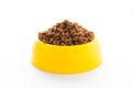 Yellow plastic bowl full with dry dog food isolated on white background. Top view grain pet food with copy space of text design. Royalty Free Stock Photo