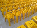 yellow plastic chairs on tile floor inside of conference hall, diagonal view and selective focus Royalty Free Stock Photo