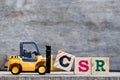 Yellow plastic forklift hold letter C to complete word CSR Royalty Free Stock Photo