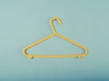 Yellow plastic hanger on a blue wall Royalty Free Stock Photo