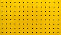 Yellow plastic perforated panel texture. Seamless tile abstract background. Pegboard Royalty Free Stock Photo