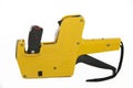 Yellow plastic price label gun on white Royalty Free Stock Photo