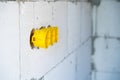Yellow plastic recessed sockets, installation box for a socket in an aerated concrete block wall