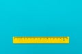 Yellow plastic ruler on the turquoise blue Royalty Free Stock Photo