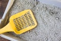 Yellow plastic scoop on the gray litter box, filled by blue litter sand Royalty Free Stock Photo