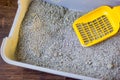 Yellow plastic scoop on the pet litterbox. Royalty Free Stock Photo