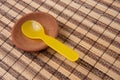 Yellow plastic spoon in clay disk